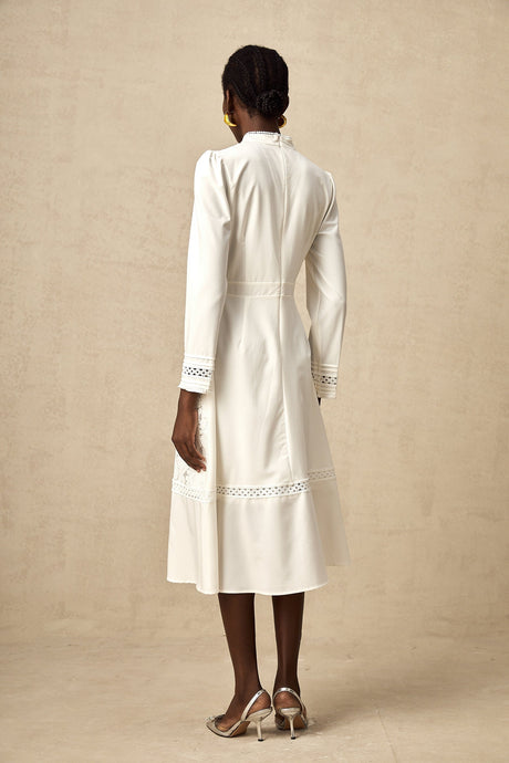 A white midi dress with panelled design and embroidery details named Madeleine featuring a feminine silhouette and delicate stitching throughout