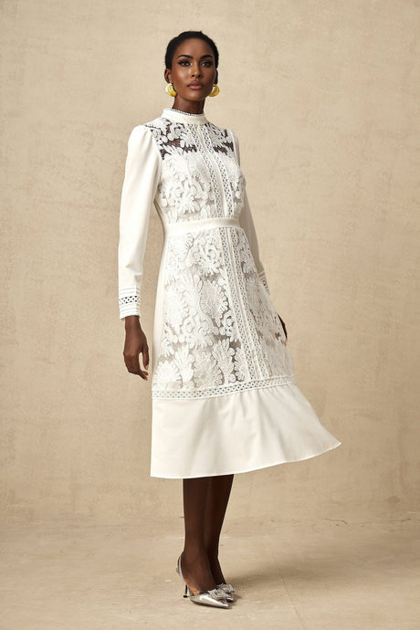 A white midi dress with panelled design and embroidery details named Madeleine featuring a feminine silhouette and intricate stitching throughout the fabric