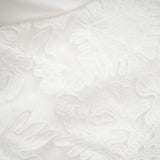 A white midi dress with panelled design and embroidery details named Madeleine featuring a fitted bodice and flowy skirt