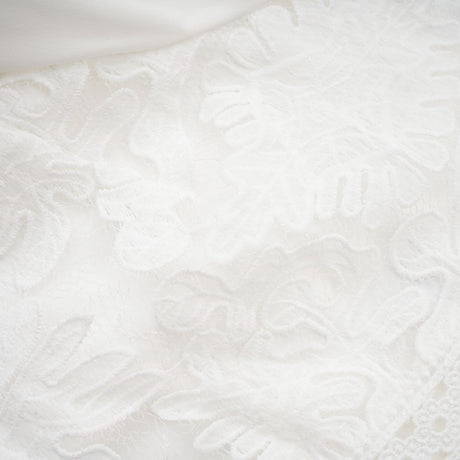 A white midi dress with panelled design and embroidery details named Madeleine featuring a fitted bodice and flowy skirt