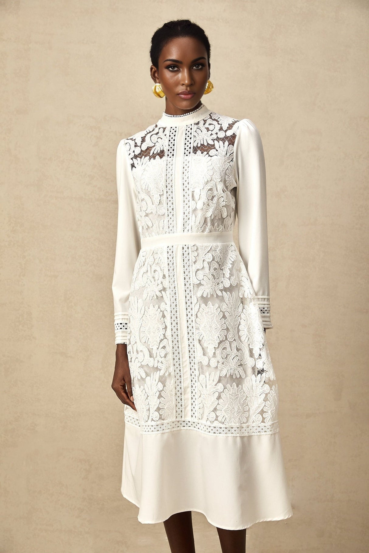 A white midi dress with panelled design and embroidery details named Madeleine featuring a fitted silhouette and delicate floral patterns
