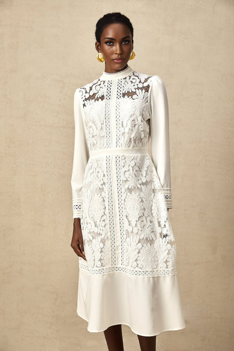 A white midi dress with panelled design and embroidery details named Madeleine featuring a fitted silhouette and delicate floral patterns