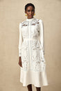 A white midi dress with panelled design and embroidery details named Madeleine featuring a fitted silhouette and delicate floral patterns