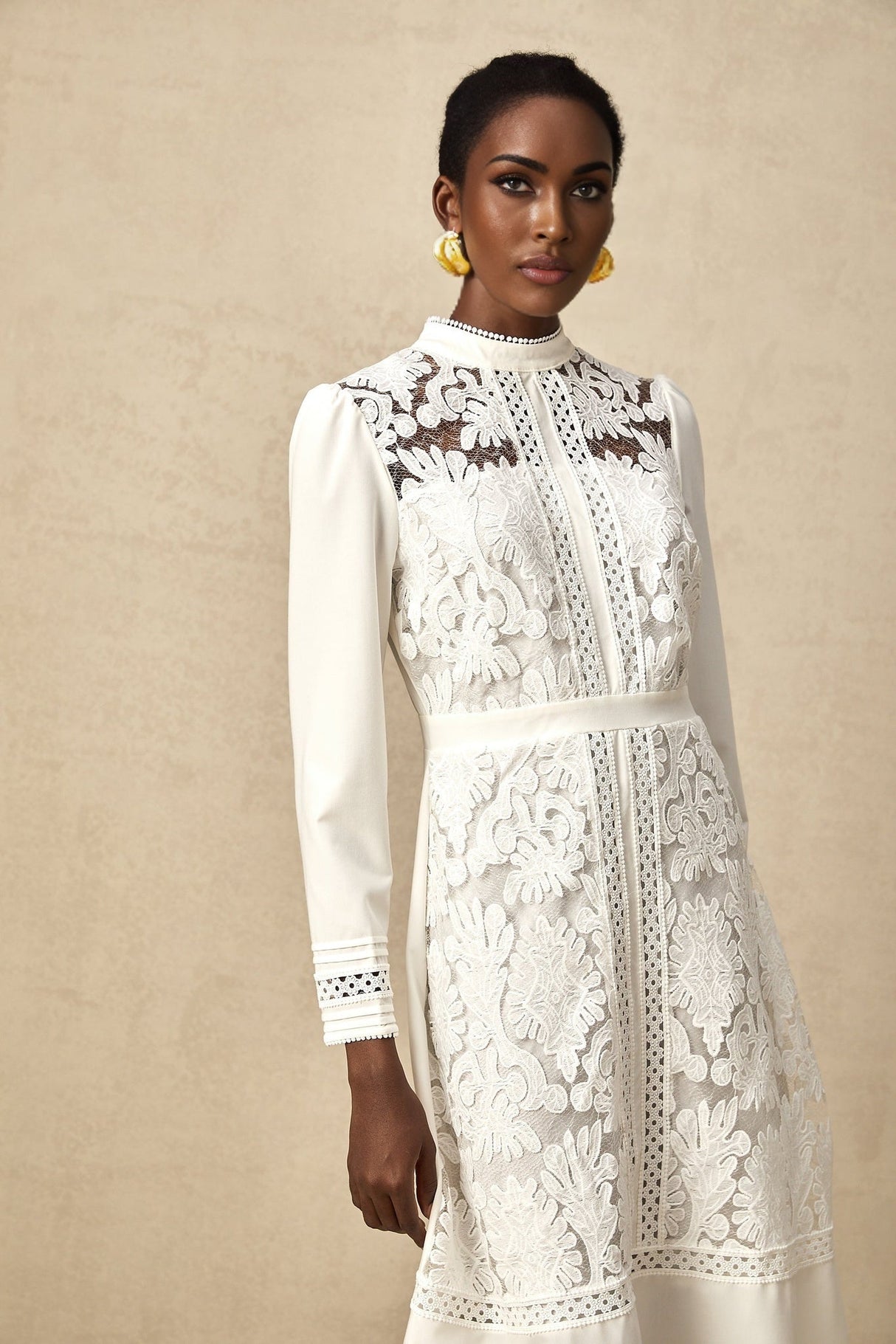 A white midi dress with panelled design and embroidery details named Madeleine featuring a fitted silhouette and delicate floral stitching throughout