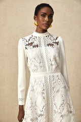 A white midi dress with panelled design and embroidery details named Madeleine featuring a fitted silhouette and delicate needlework accents