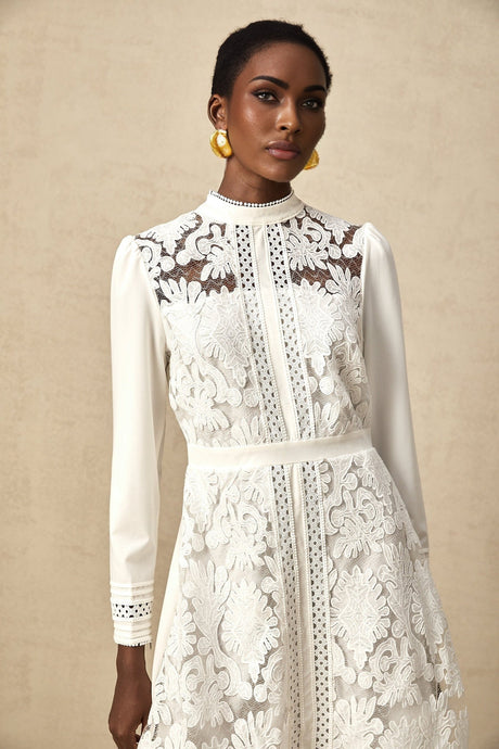 A white midi dress with panelled design and embroidery details named Madeleine featuring a fitted silhouette and delicate needlework accents