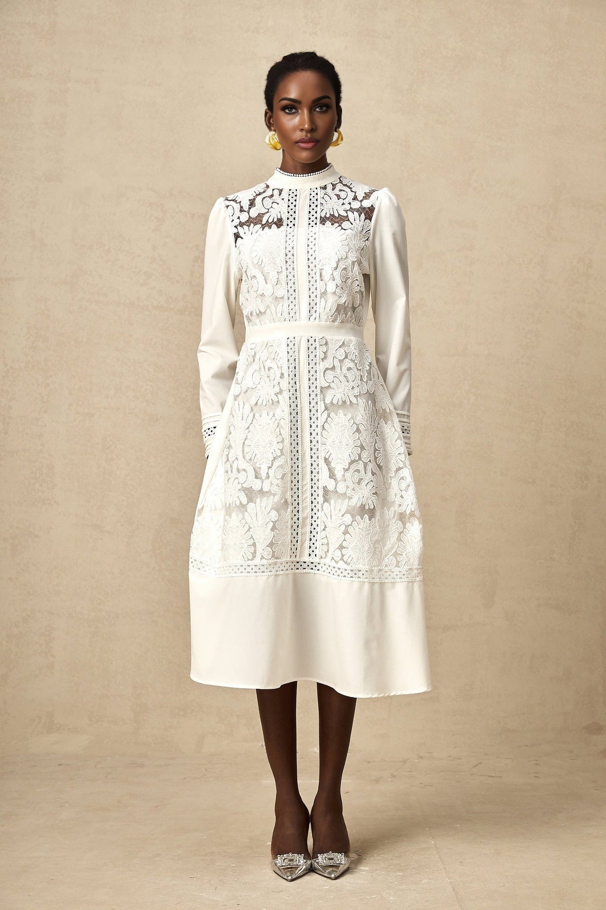 A white midi dress with panelled design and embroidery details named Madeleine featuring a fitted silhouette and delicate stitching patterns