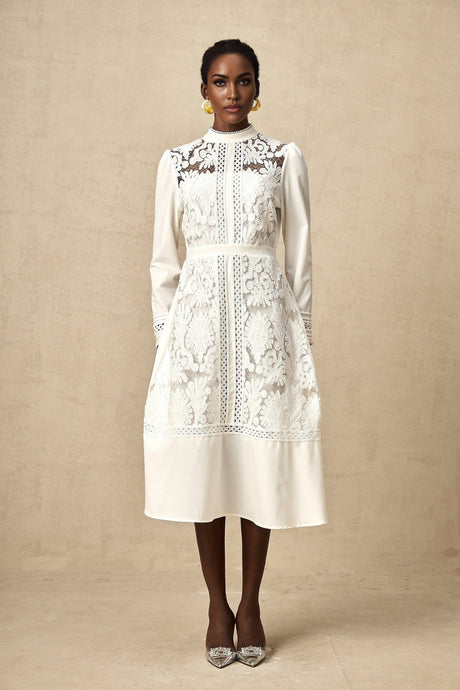 A white midi dress with panelled design and embroidery details named Madeleine featuring a fitted silhouette and delicate stitching patterns