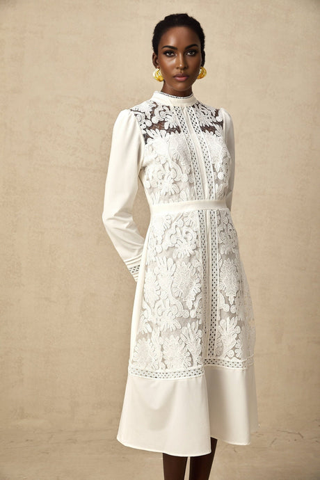 A white midi dress with panelled design and embroidery details named Madeleine featuring a fitted silhouette and delicate stitching throughout