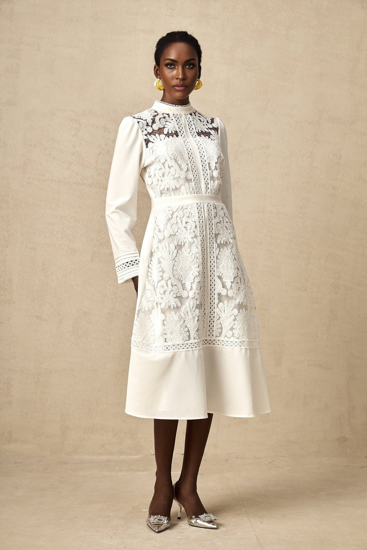 A white midi dress with panelled design and embroidery details named Madeleine featuring a fitted silhouette and delicate stitching throughout