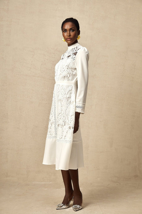 A white midi dress with panelled design and embroidery details named Madeleine featuring a flowy silhouette and delicate stitching patterns