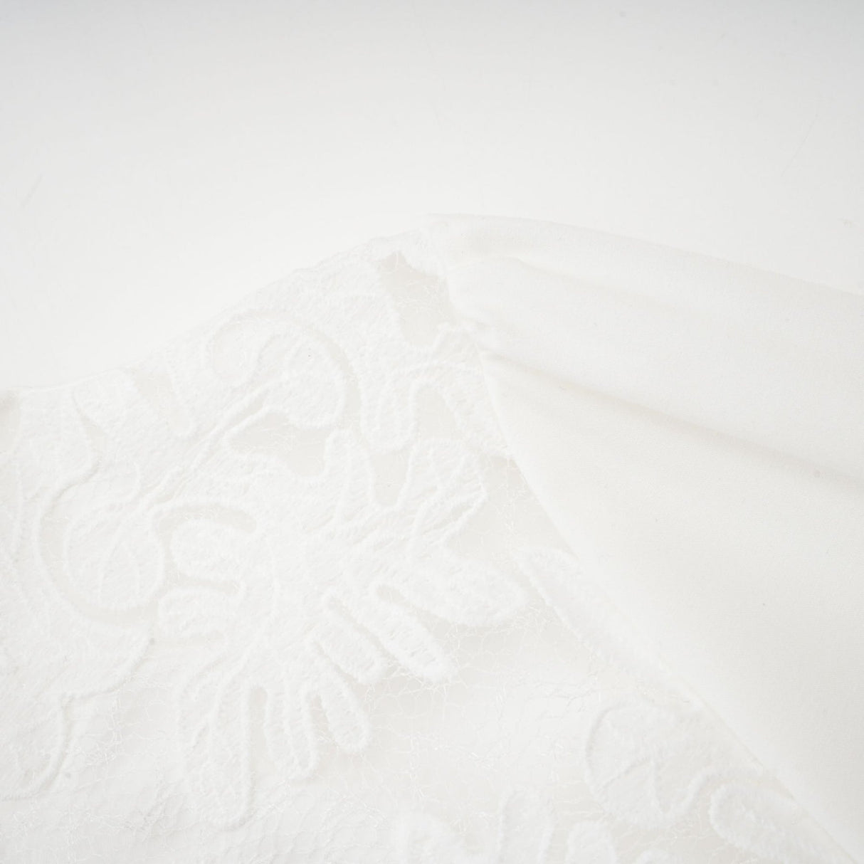 A white midi dress with panelled design and embroidery details named Madeleine featuring a flowy silhouette and delicate stitching throughout