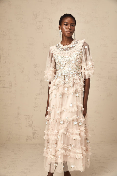 A white midi dress with tiered ruffles and floral embroidery details featuring a fitted bodice and flowing skirt