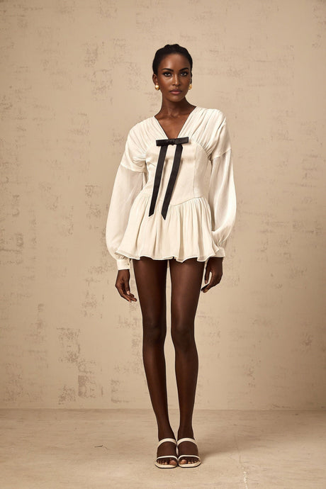 A white mini dress with a bowknot detail and glitter accents named Lina