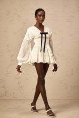 A white mini dress with a bowknot detail and glitter accents named Lina