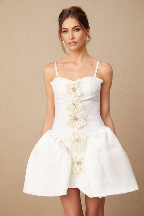 A white mini dress with a bustier top adorned with floral patterns featuring a flower motif design