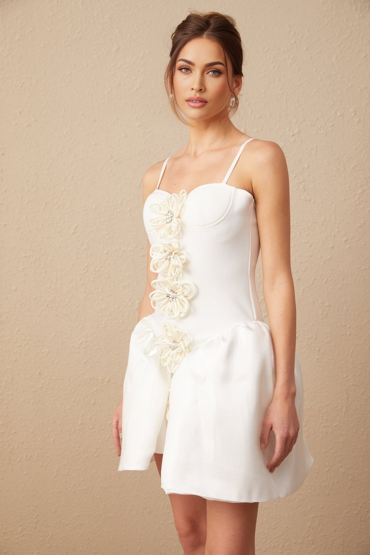 A white mini dress with a bustier top featuring a floral motif pattern throughout the fabric