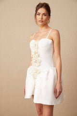 A white mini dress with a bustier top featuring a floral motif pattern throughout the fabric