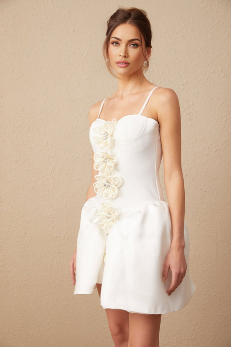 A white mini dress with a bustier top featuring a floral motif pattern throughout the fabric