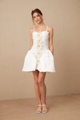 A white mini dress with a bustier top featuring a floral pattern The dress has a fitted bodice and a short skirt