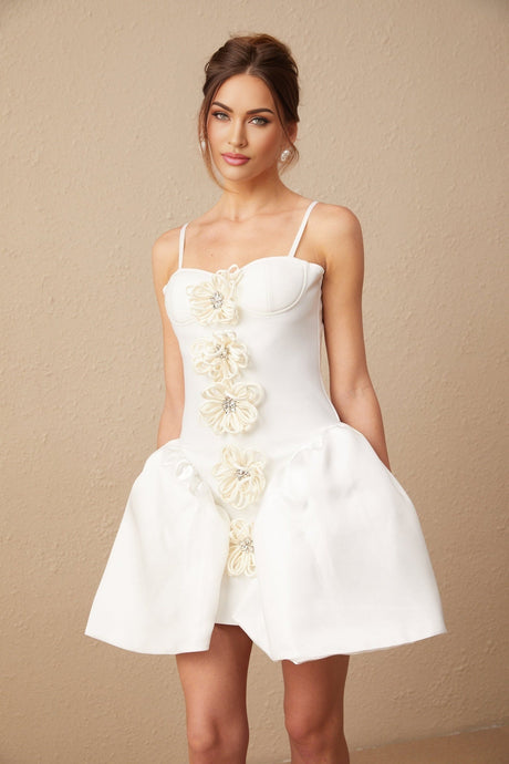 A white mini dress with a bustier top featuring a floral pattern throughout the fabric