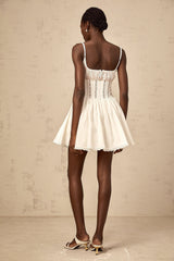 A white mini dress with a corsetstyle bodice featuring delicate lace details and a short skirt