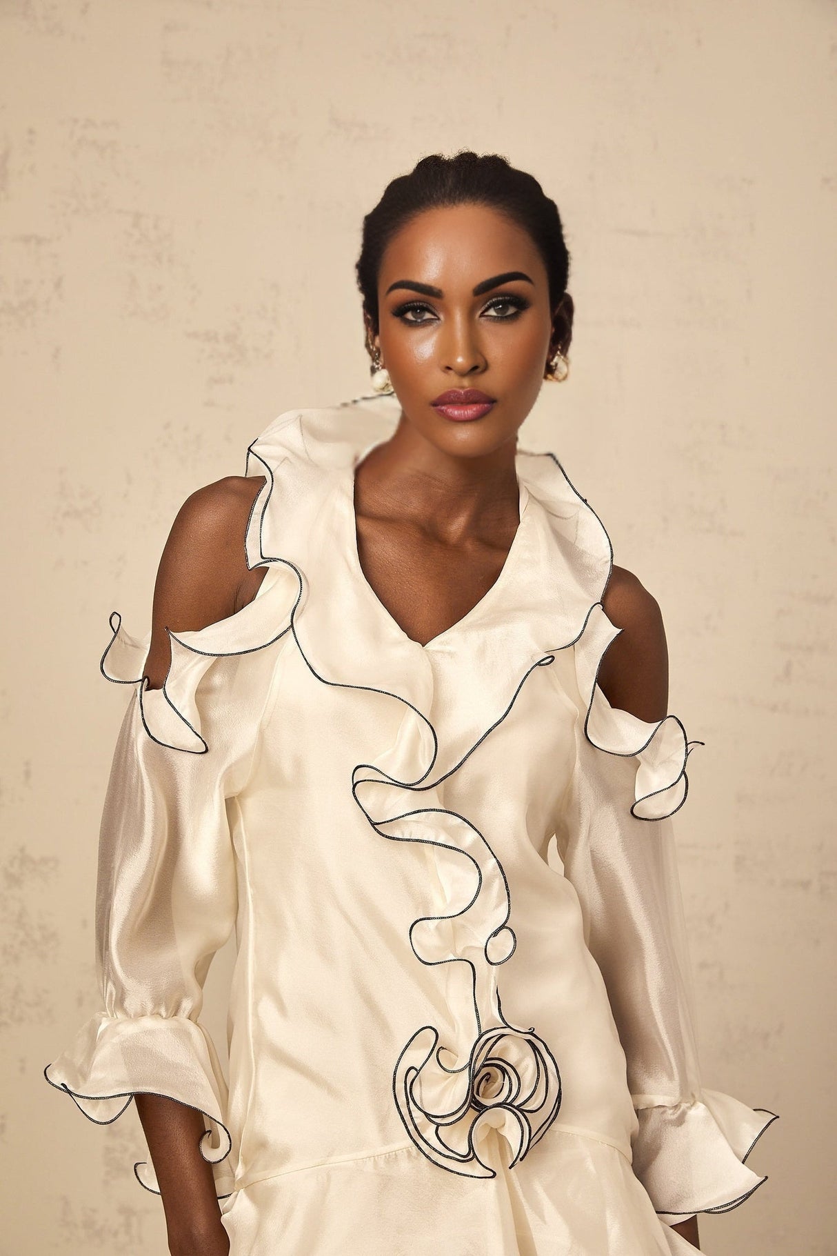 A white mini dress with a flounce design and ribbon details named Tiphaine