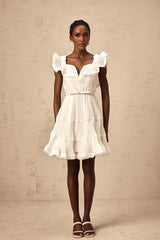 A white mini dress with a frilled neckline and pleated design named Éliane