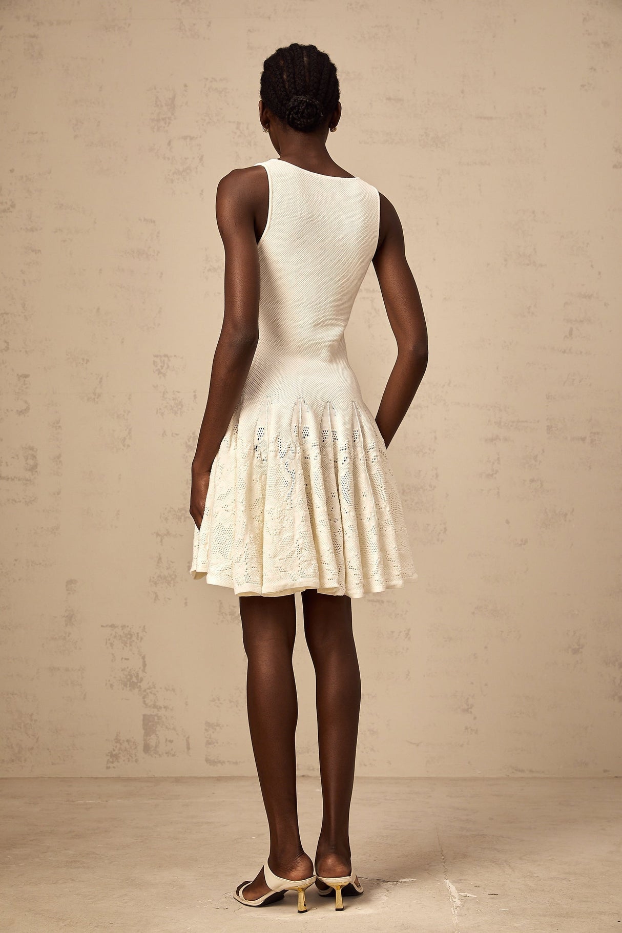 A white mini dress with a jacquard knit pattern featuring a short hemline and textured fabric design