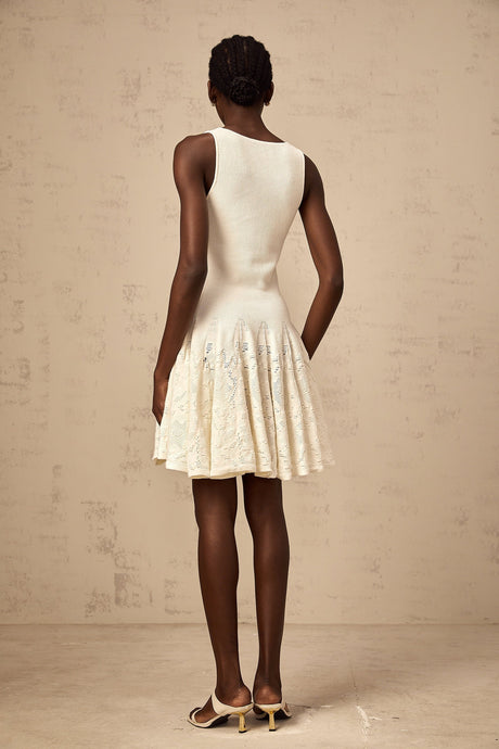 A white mini dress with a jacquard knit pattern featuring a short hemline and textured fabric design