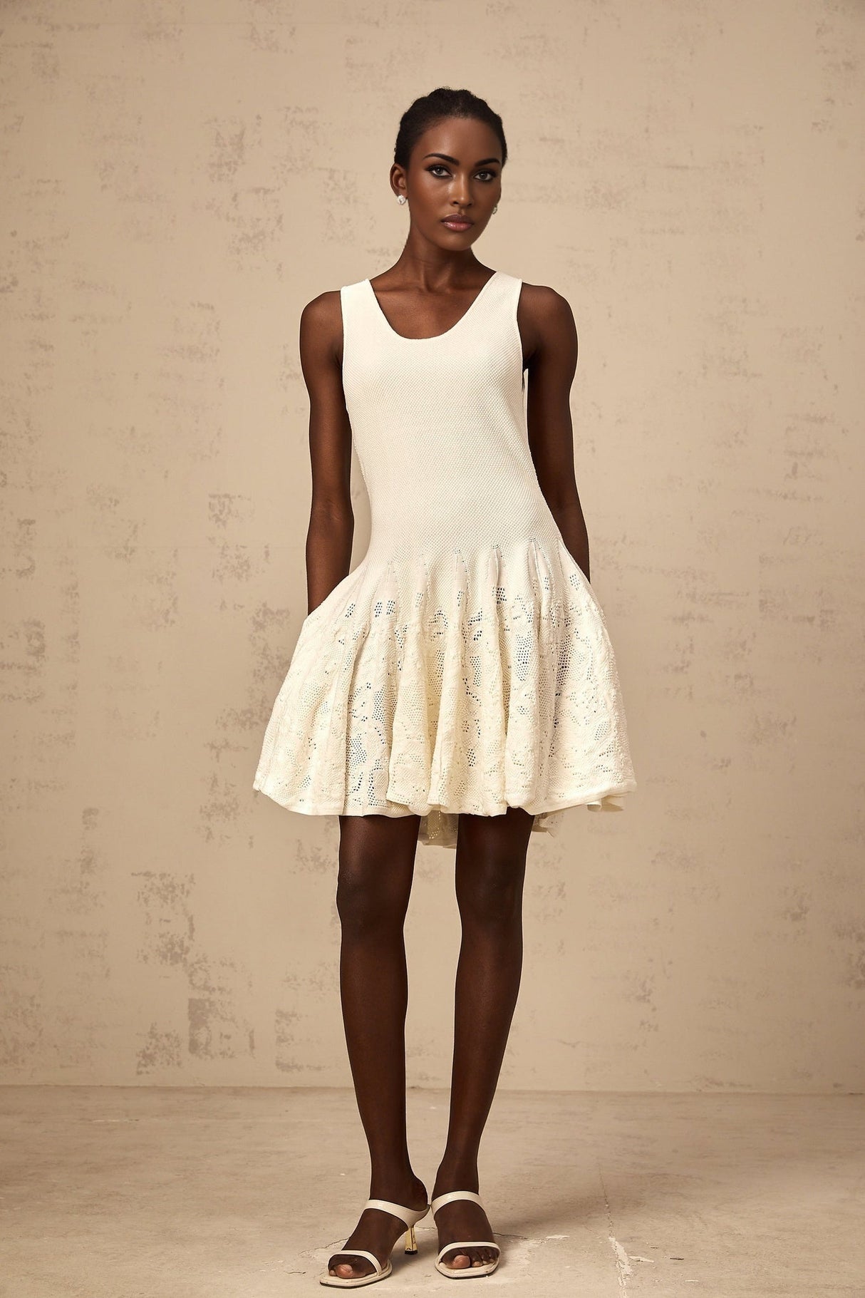 A white mini dress with a jacquard knit pattern named Eleonore worn by a model standing against a plain background