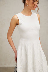 A white mini dress with a star pattern knitted into the fabric featuring a jasmine design