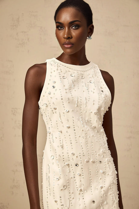 A white mini dress with an Aline silhouette featuring embellishments and named Flavie