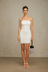 A white mini dress with an offshoulder neckline adorned with sparkling sequins