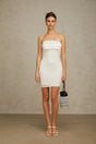A white mini dress with an offshoulder neckline adorned with sparkling sequins