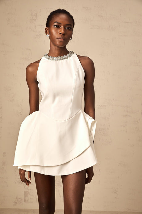 A white mini dress with crystal embellishments and layered design worn by a model named Denise