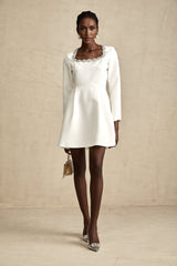 A white mini dress with crystal embellishments in an Aline silhouette named Angelique
