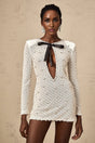 A white mini dress with cutout details and a decorative bow accent featuring the Adalasia design