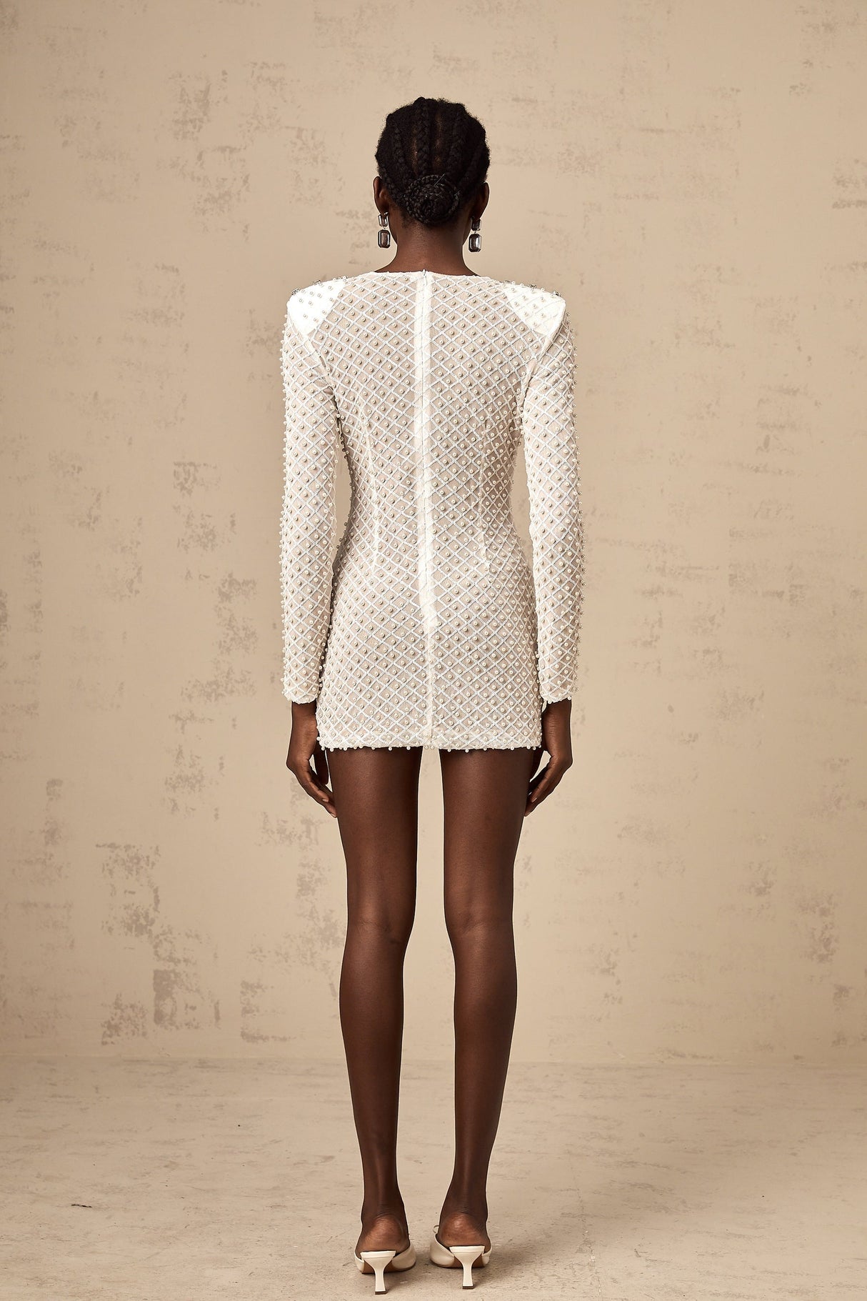 A white mini dress with cutout details and a decorative bowknot embellishment
