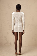 A white mini dress with cutout details and a decorative bowknot embellishment