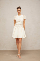 A white mini dress with delicate flower embroidery details covering the fabric Maelle brand