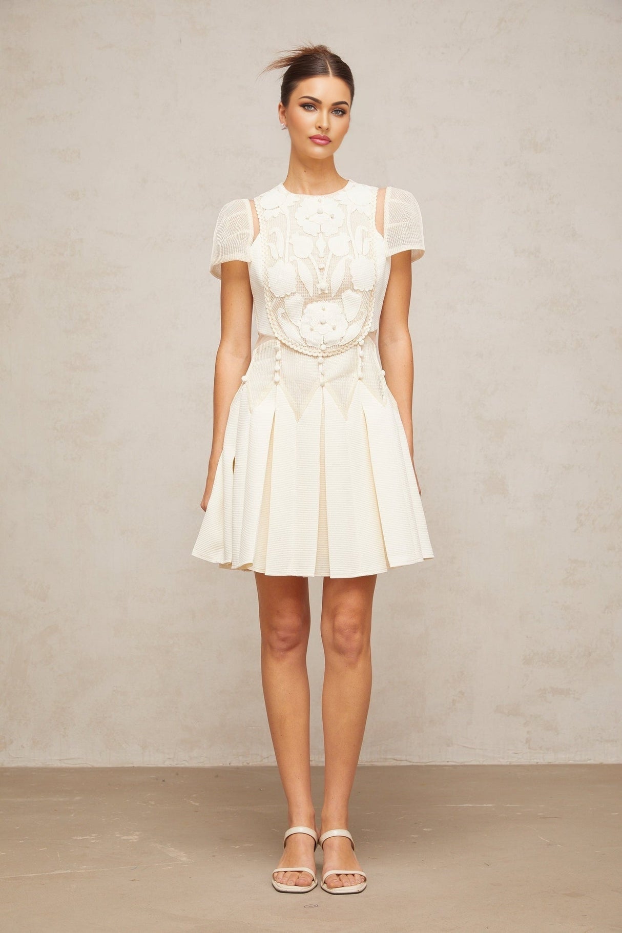 A white mini dress with delicate flower embroidery pattern adorning the fabric