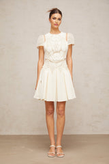 A white mini dress with delicate flower embroidery pattern adorning the fabric