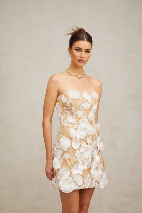 A white mini dress with floral applique detailing featuring a design inspired by Veronica flowers