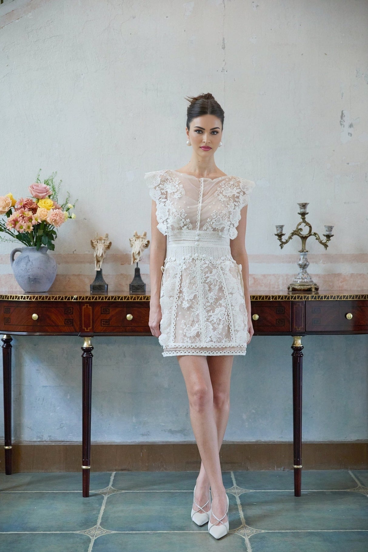 A white mini dress with floral embroidery and lace details featuring a delicate and feminine design