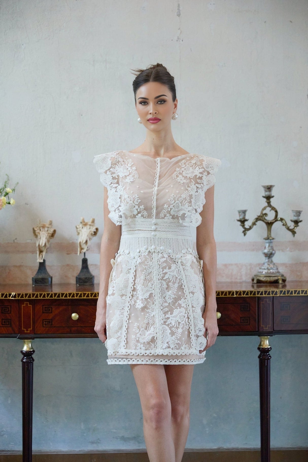 A white mini dress with floral embroidery and lace details