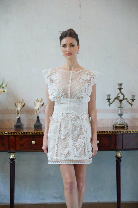 A white mini dress with floral embroidery and lace details