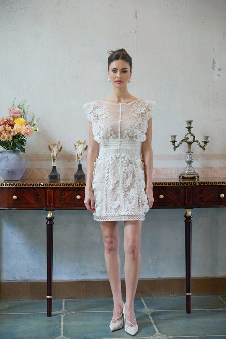 A white mini dress with floral embroidery and lace details