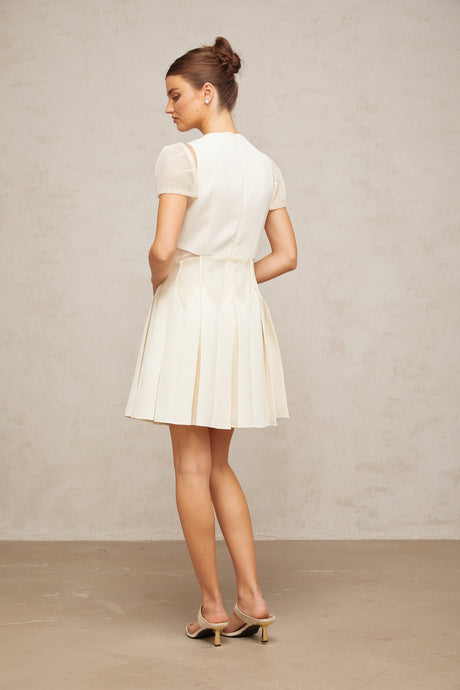 A white mini dress with floral embroidery details featuring a sleeveless design and a short hemline