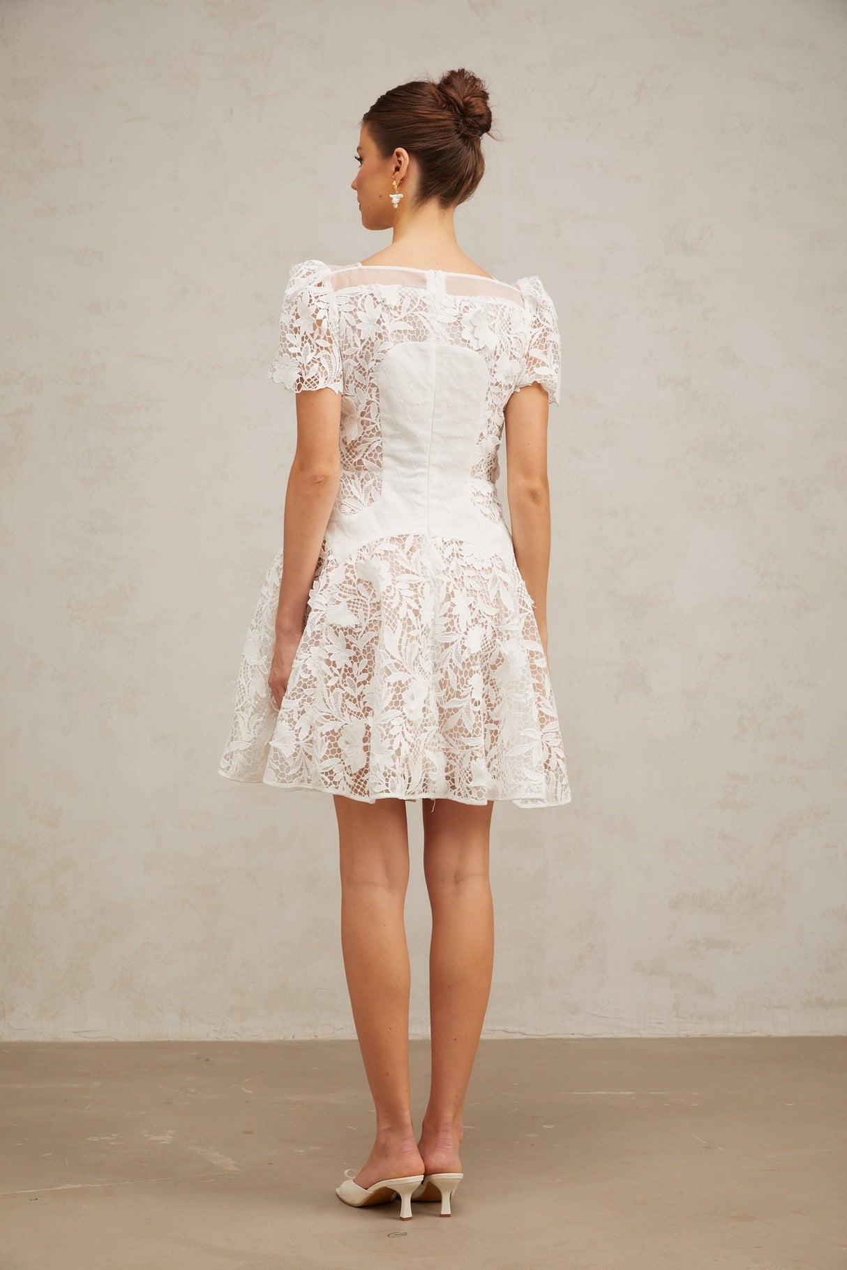 A white mini dress with floral lace pattern and puff sleeves featuring a romantic Josette design